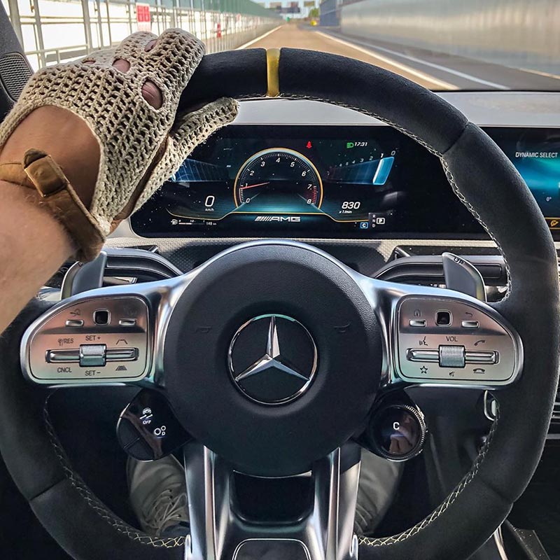 Driving gloves resting on a Mercedes steering wheel